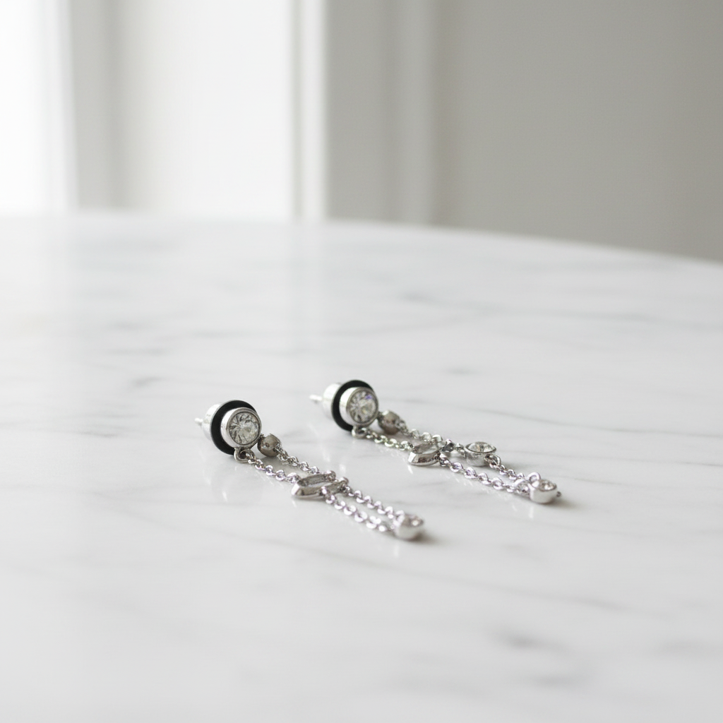 Coach Crystal Chain Earrings on marble surface