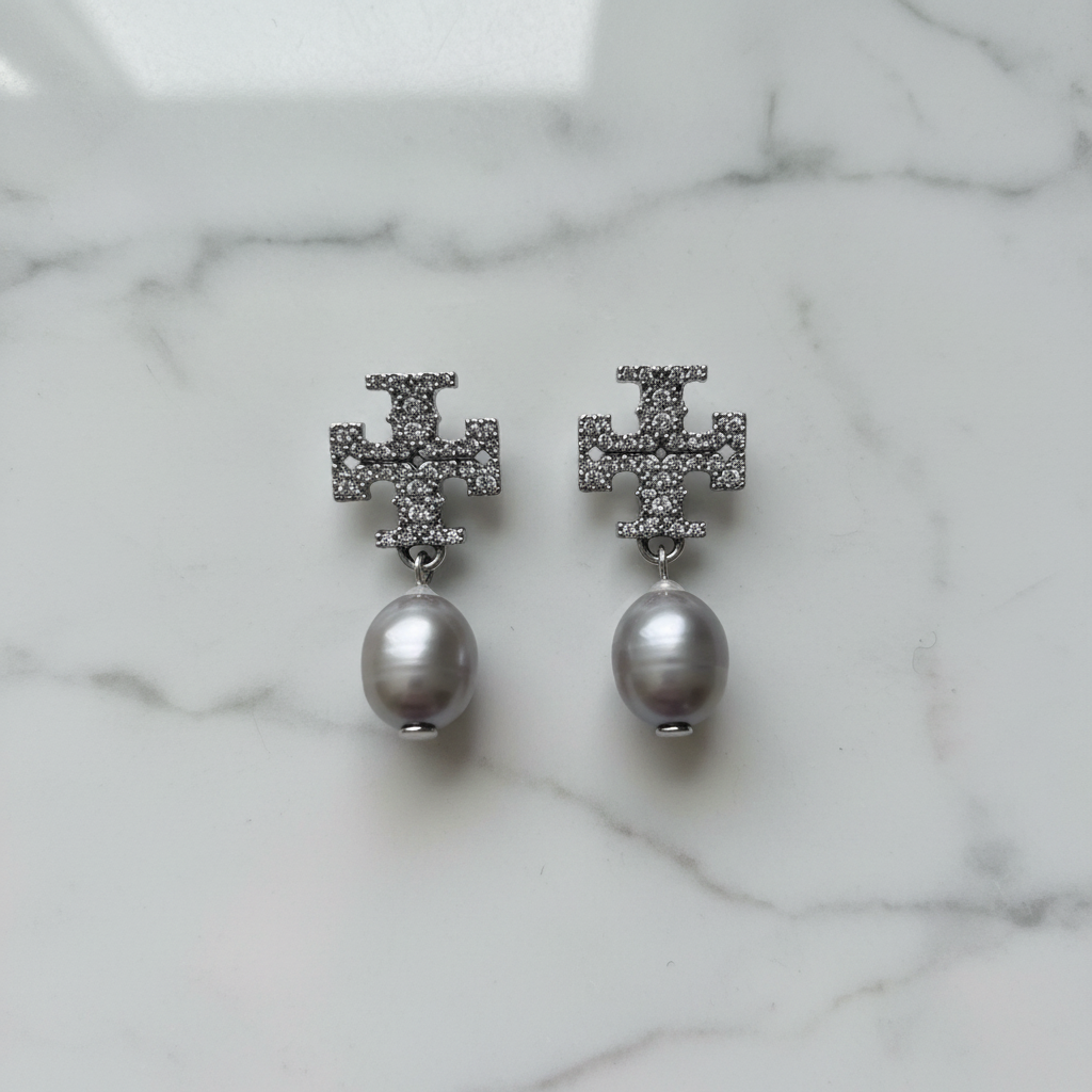 Tory Burch Kira Pavé Pearl gray drop earrings flat lay on white marble