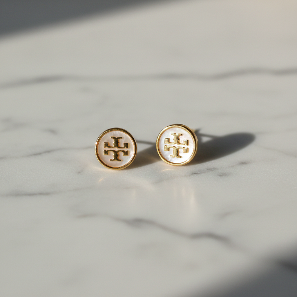 Tory Burch Kira Icon Stud Earrings with Mother of Pearl styled flat lay