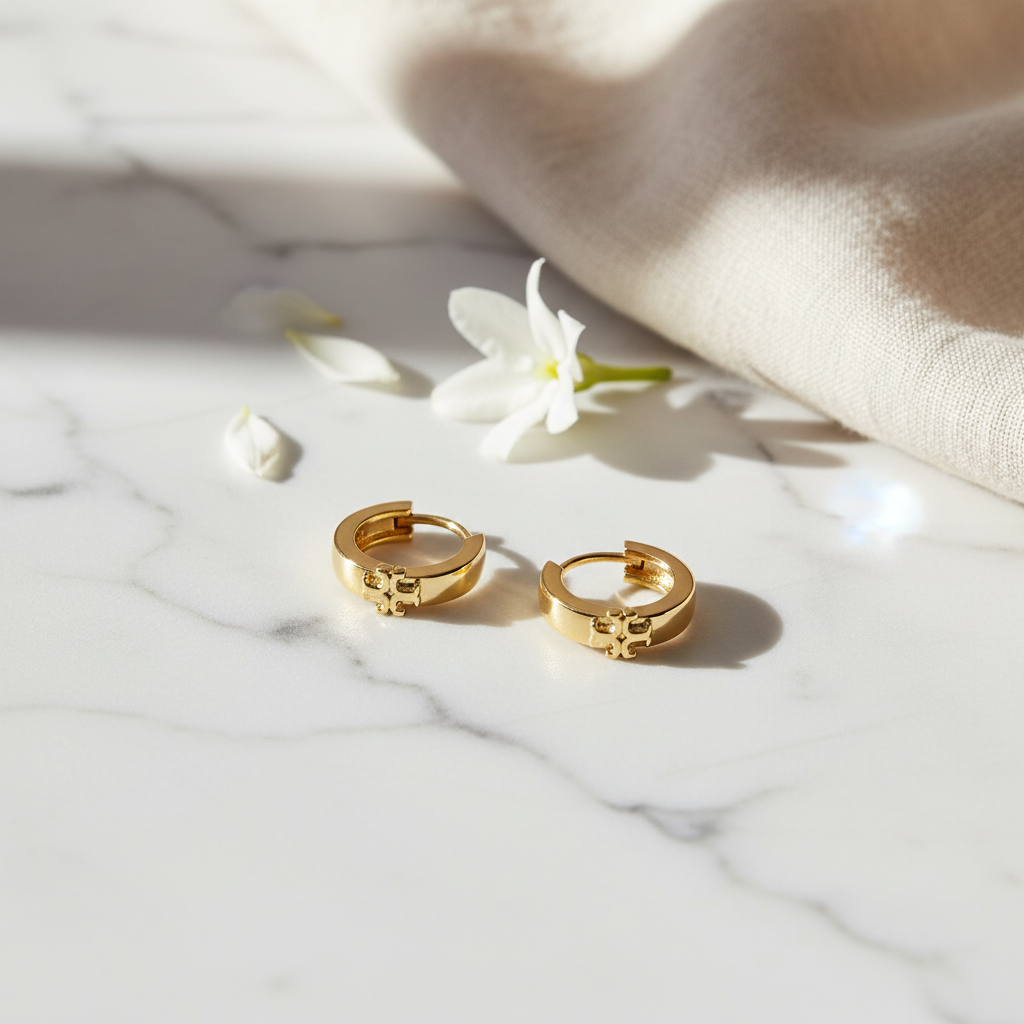 Tory Burch Icon Huggie Earrings marble flat lay