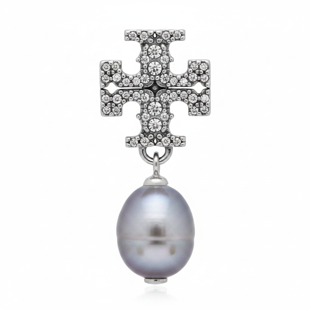 Close-up macro of Tory Burch Kira Pavé cross and gray pearl drop
