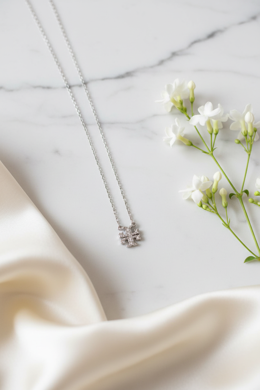 Tory Burch Kira Pave Necklace flat lay with white flowers