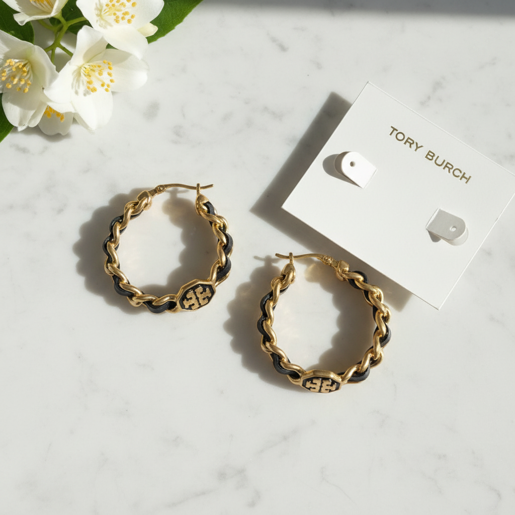 Tory Burch Marion woven hoop earrings flat lay on white marble
