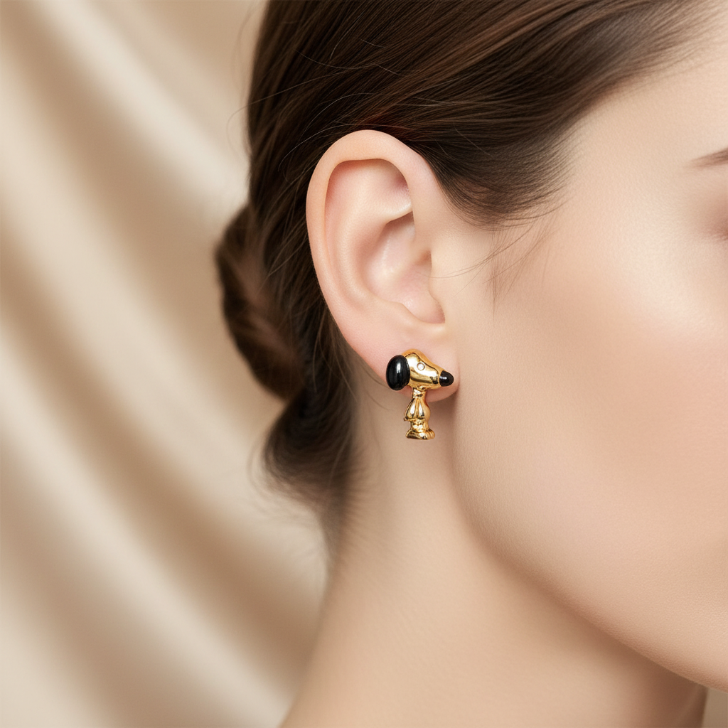 Coach x Peanuts Snoopy Gold Stud Earrings worn on ear, warm playful lighting
