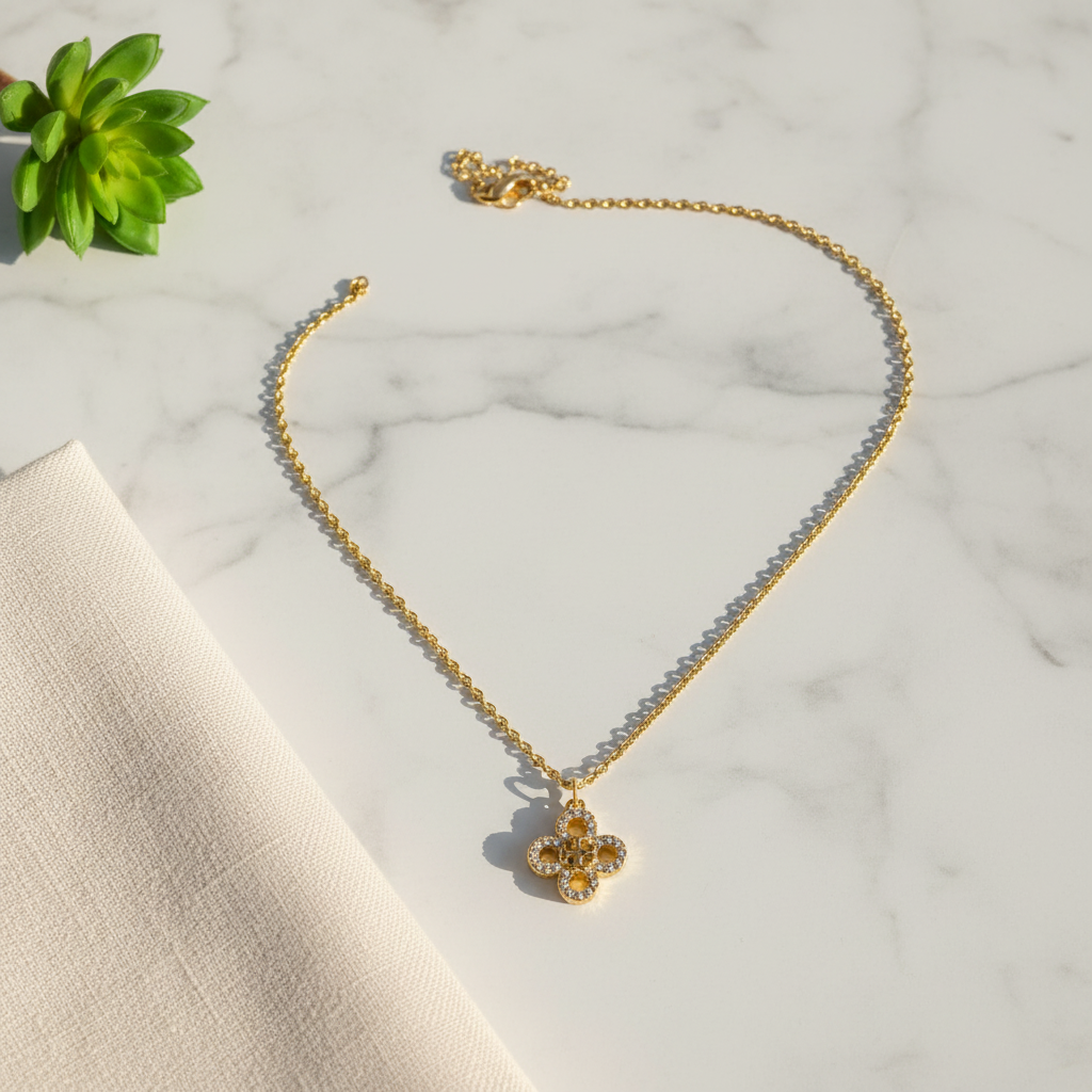 Tory Burch Kira Clover Pave Pendant Necklace marble flat lay